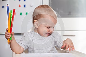 Cute baby paint using colorful pencils on white table