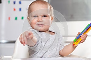 Cute baby paint using colorful pencils on white table