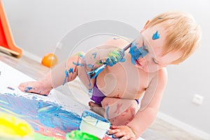 Cute baby painting with brush and paint