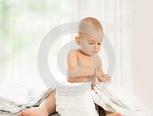 Cute baby playing with new diapers