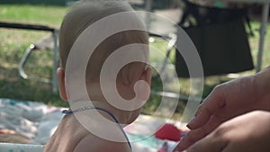 cute baby playing in the pool in summer, backyard, close-up, light blue eyes