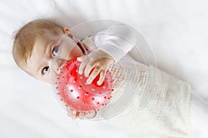 Cute baby playing with red gum ball, crawling, grabbing