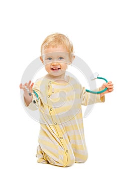 Cute baby playing stethoscope on white