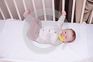 Cute baby playing with toy in bed . New born child, little girl having fun, . Family, childhood concept. copy space