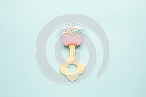 Cute baby rattle with teether on light blue background