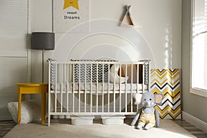 Cute baby room interior with crib and decor