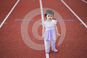 Cute baby running at sport stadium