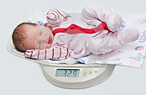 Cute baby on the scales