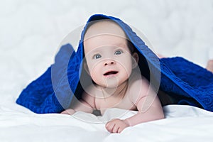 Cute baby after shower with blue towel on head