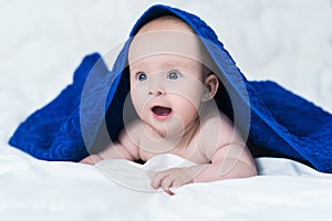 Cute baby after shower with blue towel on head