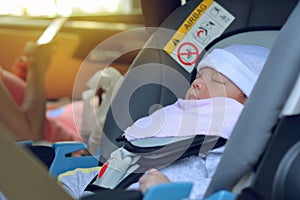 Cute baby sleeping in car seat safety drive with mother, happy family road trip travel