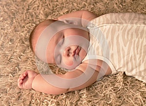 Cute baby sleeping on carpet