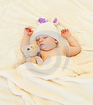 Cute baby sleeping with teddy bear on white bed home