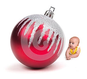 Cute Baby smiling at a Huge Christmas Ornament on white