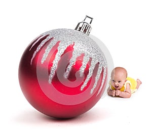 Cute Baby smiling at a Huge Christmas Ornament on white