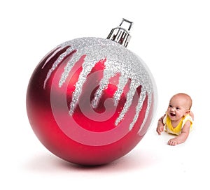 Cute Baby smiling at a Huge Christmas Ornament on white