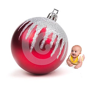 Cute Baby smiling at a Huge Christmas Ornament on white