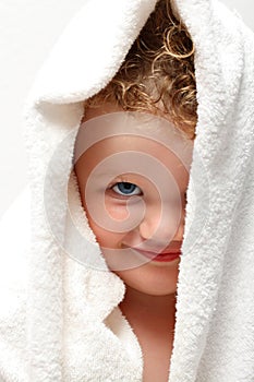 Cute baby smiling under towel with one eye covered