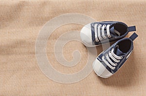 Cute baby sneakers close up on red background