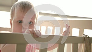 Cute baby standing in cot. Cute childhood. Toddler girl in crib