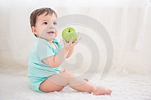 Cute baby take green apple