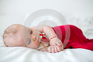 Cute baby toddler boy, sleeping with white and red bracelet