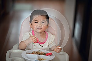 Cute baby try to eating by herself