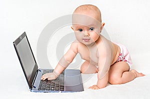 Cute baby typing on a laptop computer isolated on white