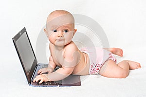 Cute baby typing on a laptop computer isolated on white