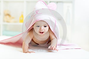 Cute baby under the towel after bathing at home