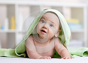 Cute baby in green towel after bathing