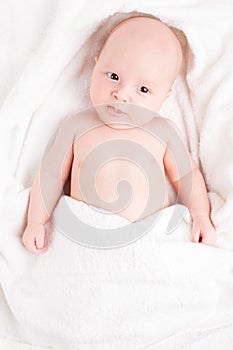 Cute baby wrapped into towels