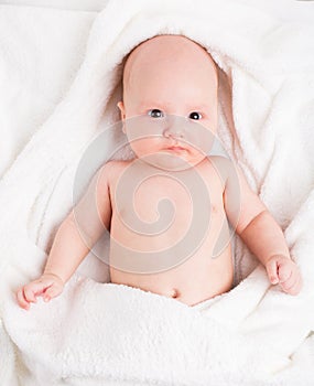 Cute baby wrapped into towels