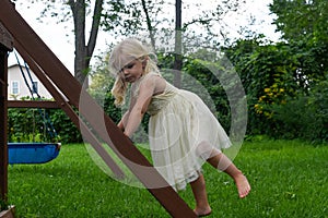 Cute barefoot girl climbing swingset ladder