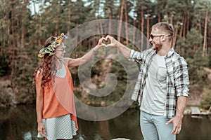 Cute beaming couple wearing sunglasses feeling extremely happy traveling together