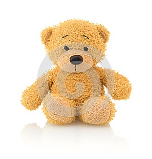 Cute bear doll isolated on white background with shadow reflection. Playful bright brown bear sitting on white underlay.