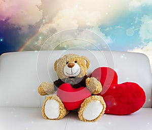 Cute bear doll sit with red heart in dreamy sweet rainbow sky