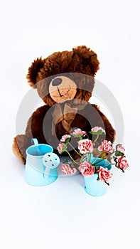 Cute bear toy With flowers in blue bucket.