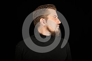 Cute bearded man, half-face portrait, black background