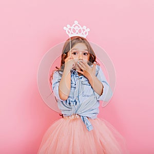 Cute beautiful carnival kid having fun  on pink background. Pretty little girl with long brunette hair, in tulle