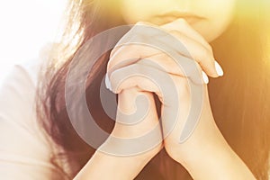 Cute beautiful girl folded her hands in prayer. A woman asks God for help