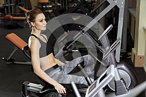 Cute beautiful girl pedaling on a stationary bike at the gym.