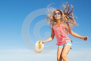 Cute beautiful girl with straw hat jump over sky