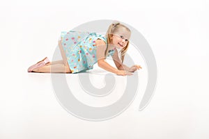 cute beautiful little blonde girl crawls on her knees, she rests with their.