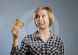 Cute beautiful woman with chocolate stain in mouth eating big delicious cookie