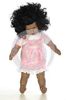 Cute black baby girl doll in a pink dress standing