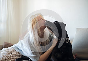 Cute  black dog licking womans face