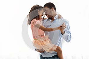 Cute black father and daughter dancing over white photo