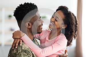 Cute black girl enjoying reunion with her father soldier