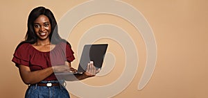 Cute black lady freelancer using laptop, panorama with copy space